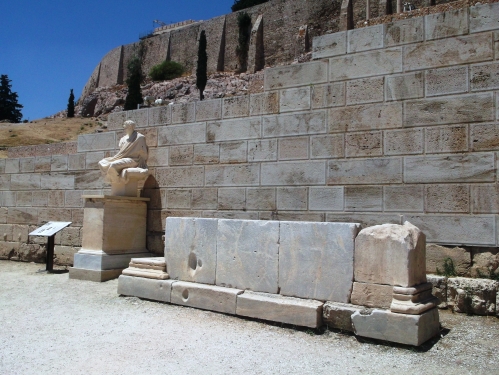 Zidul de la intrarea în Teatrul lui Dionysos şi o statuie ridicată în onoarea unuia dintre câştigătorii concursului de artă dramatică, Teatrul lui Dionysos, Atena